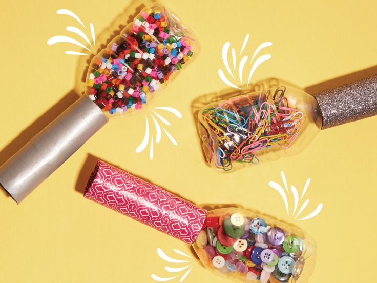 three plastic containers filled with different colored buttons next to a rolling pin and sprinkler