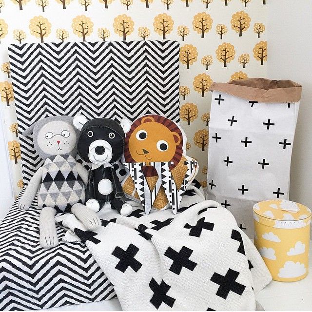 three stuffed animals sitting on top of a black and white blanket