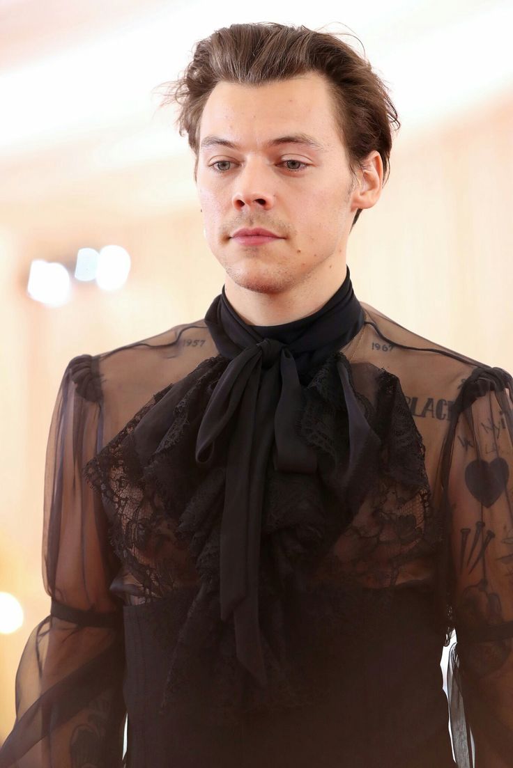 a young man wearing a black shirt and tie