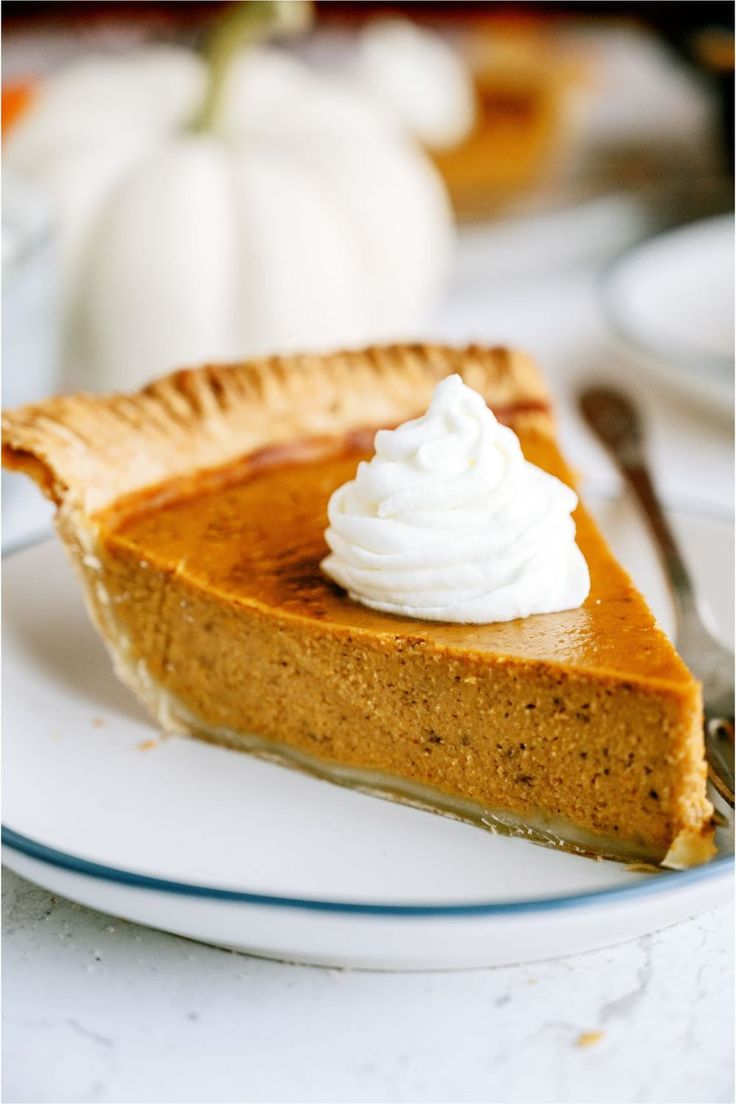 a slice of pumpkin pie with whipped cream on top