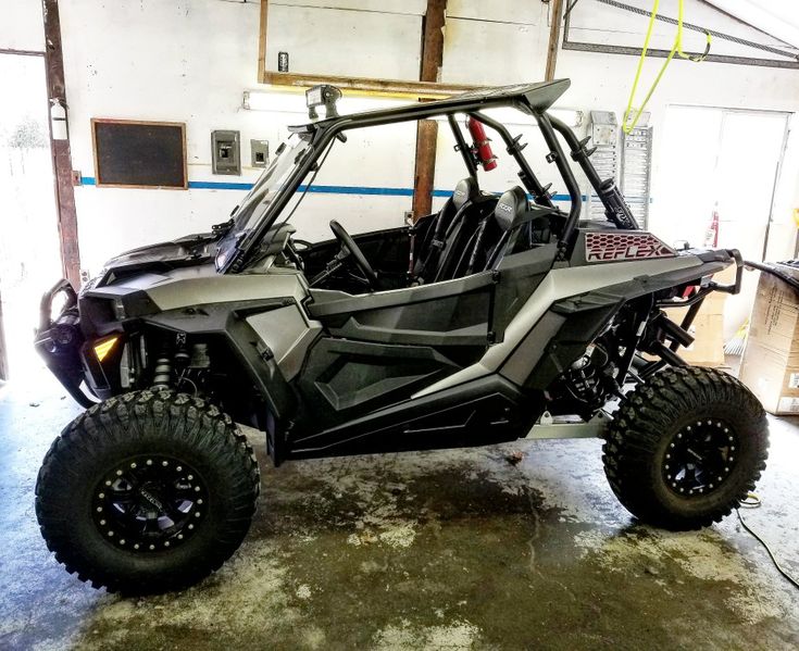 a polaris rzr is parked in a garage