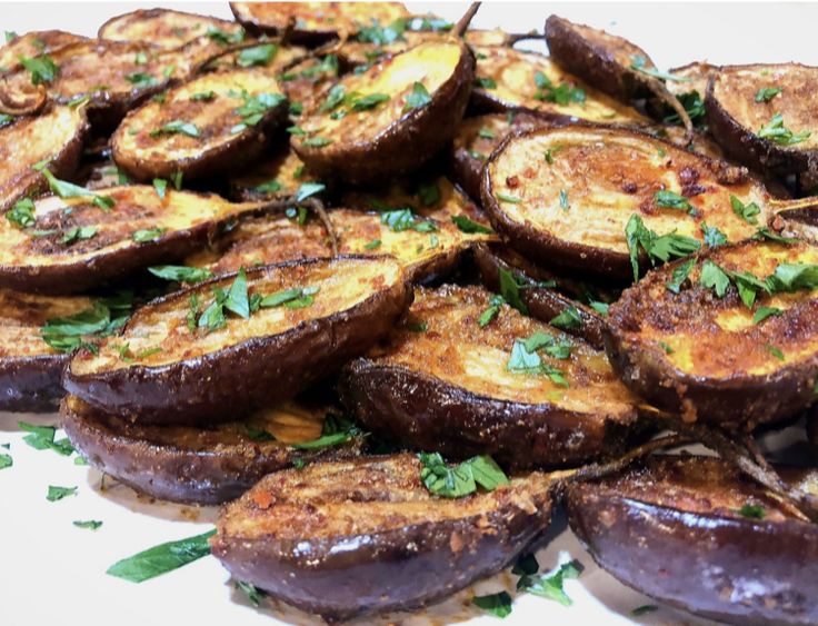 cooked eggplant slices on a plate with parsley sprinkled on top