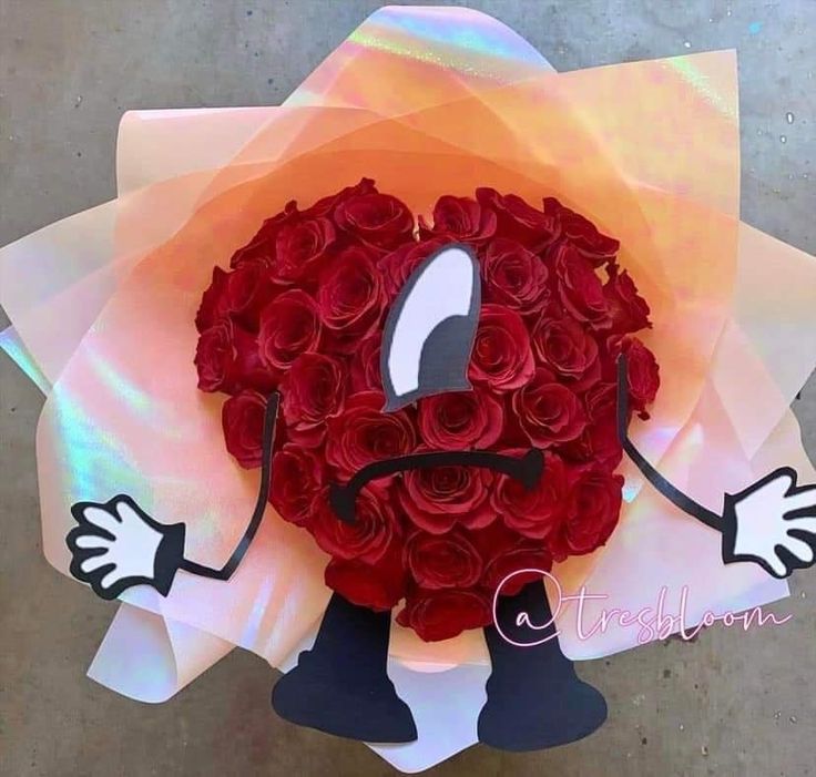 a bouquet of red roses with an emoticive expression on it's face