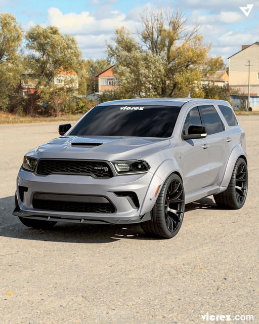 the front end of a silver dodge suv parked in a parking lot