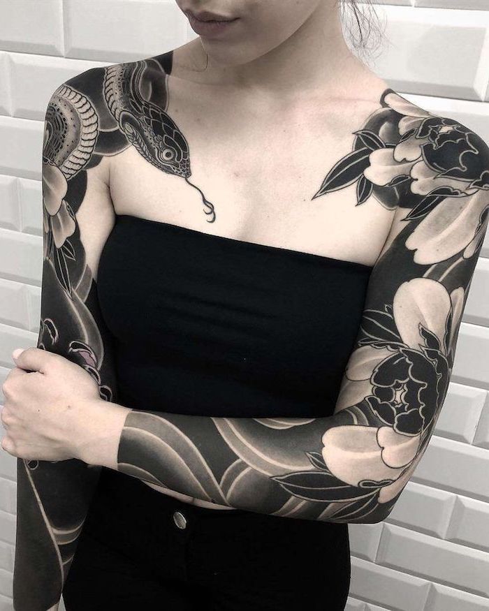 a woman with black and white tattoos on her arm