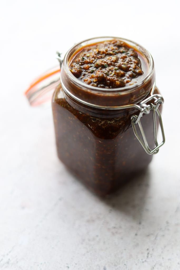 a jar filled with brown sauce sitting on top of a table