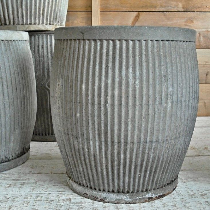 three large gray planters sitting on top of a wooden floor