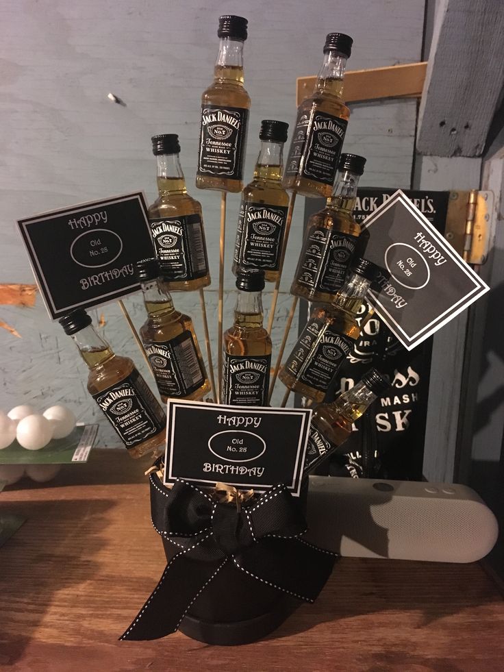 a wooden table topped with lots of bottles of liquor and labels on top of it