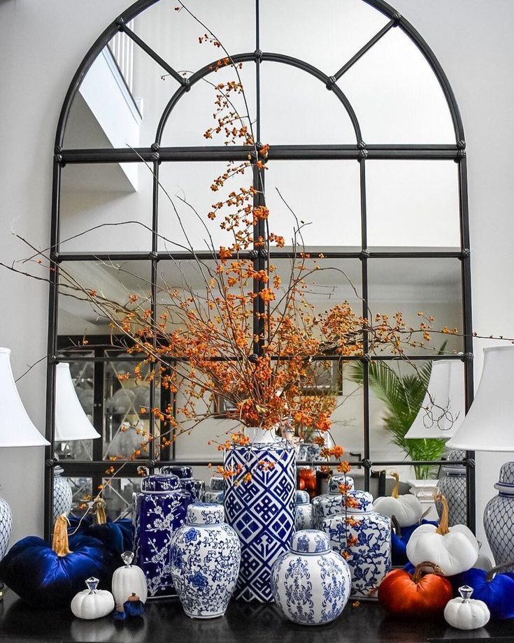 blue and white vases are sitting on a black table in front of a mirror