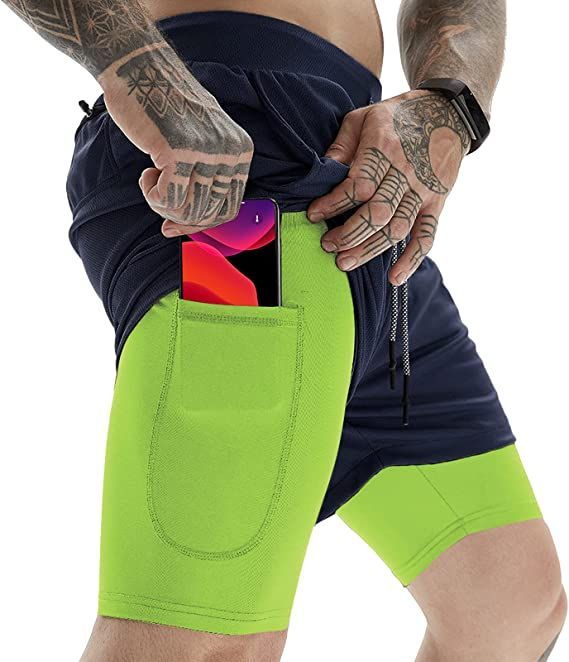 a man wearing neon green shorts and holding an iphone in his pocket