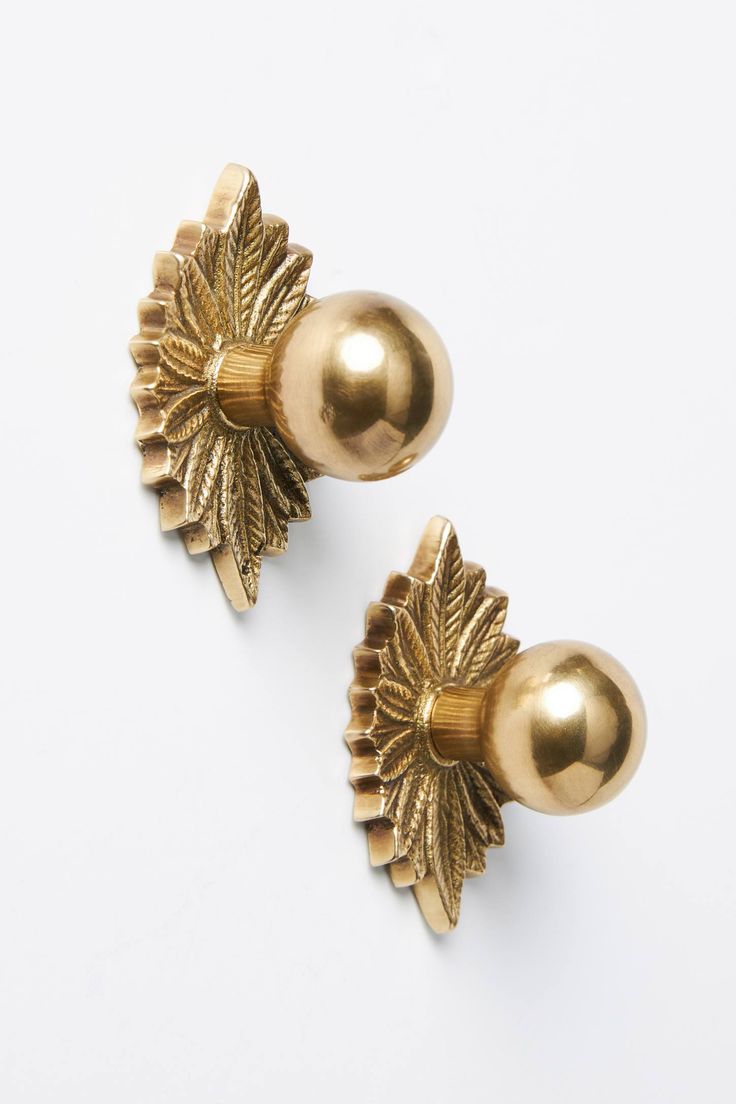 pair of gold - plated metal flowers on white background