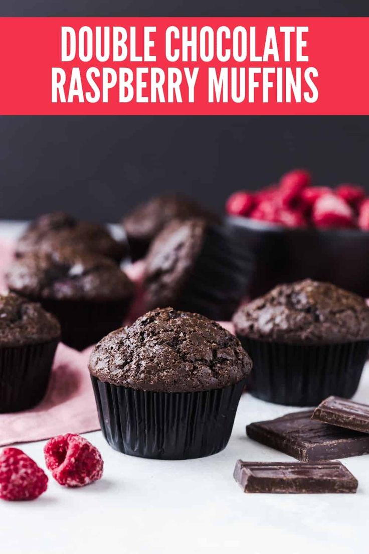 double chocolate raspberry muffins on a white table with berries in the background