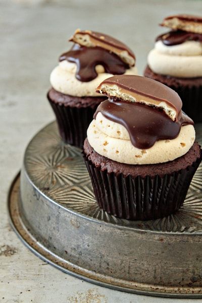 chocolate cupcakes with white frosting and chocolate drizzled on top