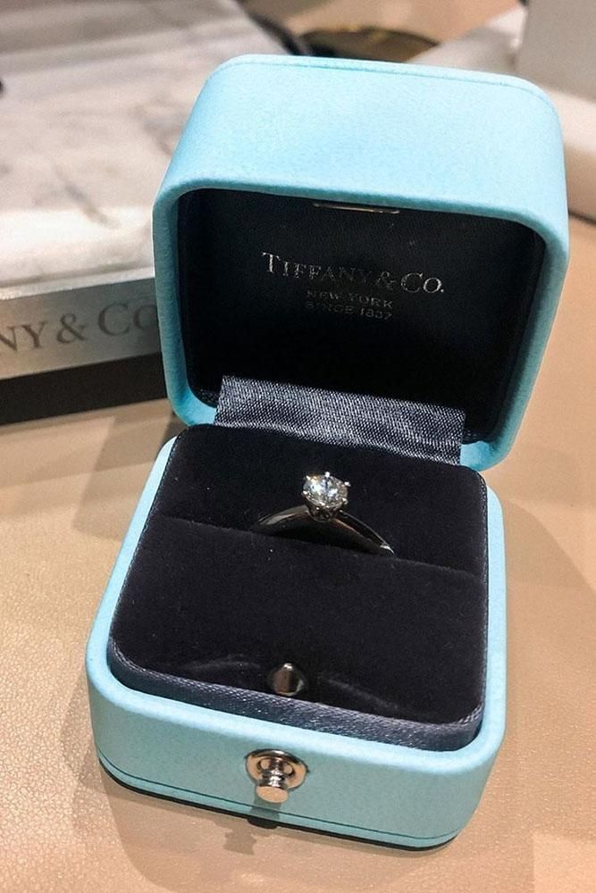 a diamond ring in a blue box on a table