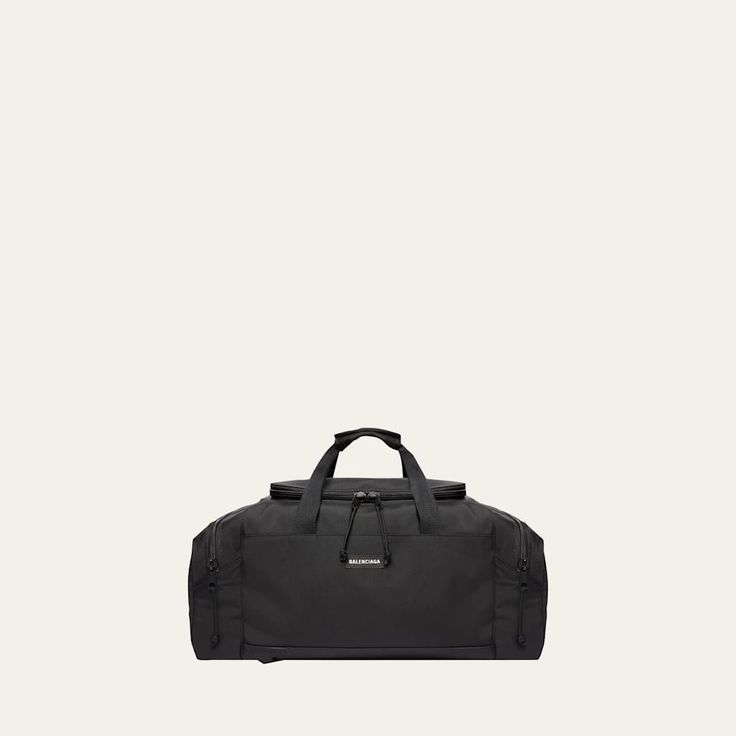 Balenciaga "Explorer" duffel bag in polyamide and polyester One top handle Adjustable padded shoulder straps Two-way zip closure Exterior, two side zip pockets Interior, one patch pocket Black matte hardware Approx. 12.6"H x 23.6"W x 11.81"D Lining: Canvas/cotton Made in Italy