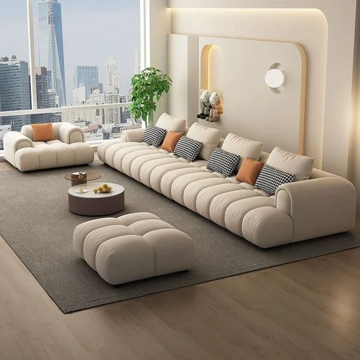 a modern living room with white furniture and large windows overlooking the cityscape in the background