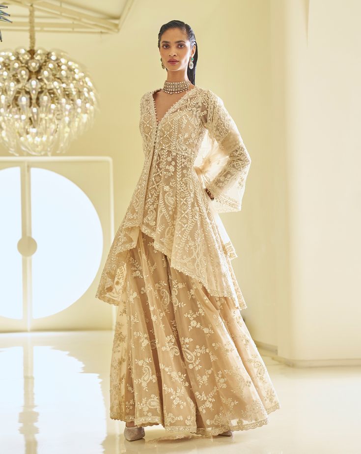 This high-low jacket sharara set features ivory thread, sequin, and pearl embroidery. The full-sleeved top shows pearl detail along the neckline, wrist, and at the hem of the Sharara top. It is paired with a fully embroidered dupatta.From Seema Gujral's Fiori - the sharara edit collection. DELIVERY TIME Please allow 8-12 weeks for your outfit to arrive. FABRIC DETAILSNet Professional cleaning only. Sharara Top, Jacket Sharara, Dotti Dresses, Full Sleeves Top, Gharara Designs, Eid Clothes, Indian Traditional Wear, Seema Gujral, Sharara Designs