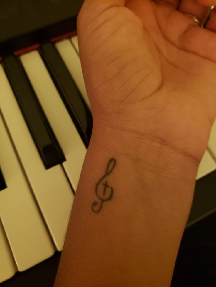 a person with a musical note tattoo on their wrist