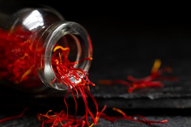 a glass jar filled with red liquid on top of a black table next to other items