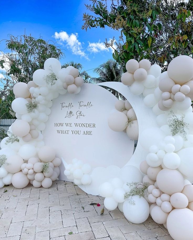 an arch made out of balloons with the words, love we wonder what you are