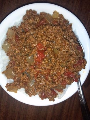 a white plate topped with meat and veggies on top of a wooden table