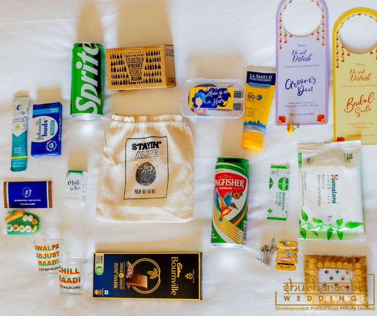 the contents of a diaper bag laid out on a bed, including toothpaste and other items