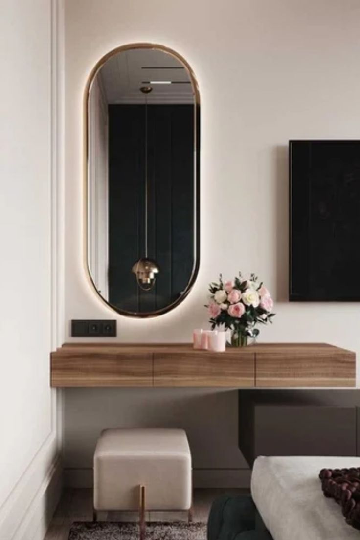 a bedroom with a vanity, mirror and flowers on the table in front of it