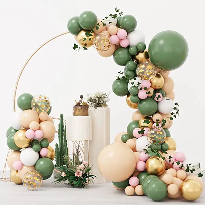 an arch made out of balloons and greenery is shown in front of a white backdrop