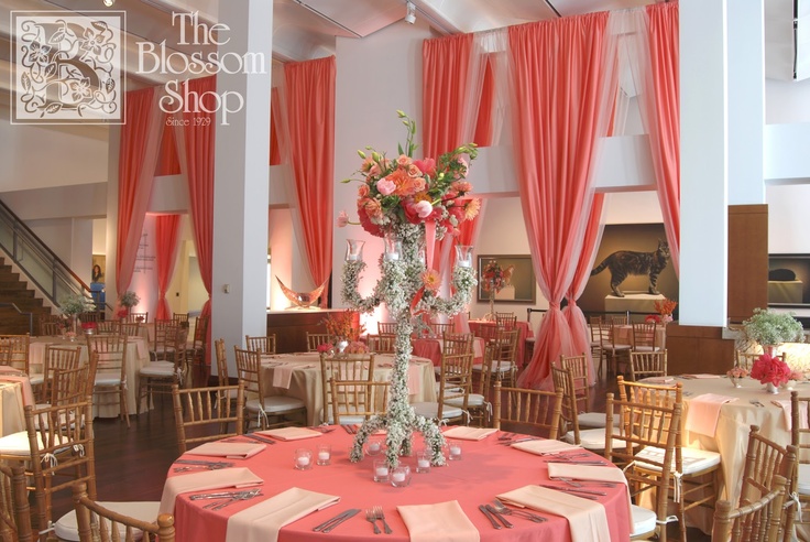 a room filled with tables and chairs covered in pink drapes