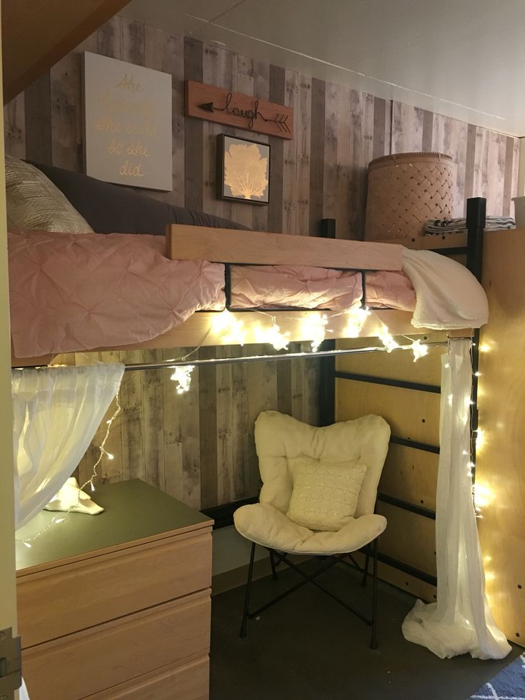 a bedroom with bunk beds and lights on the ceiling, along with a white chair