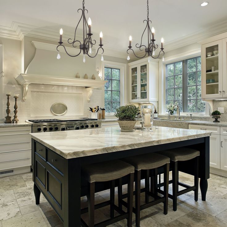 a large kitchen with marble counter tops and white cabinets