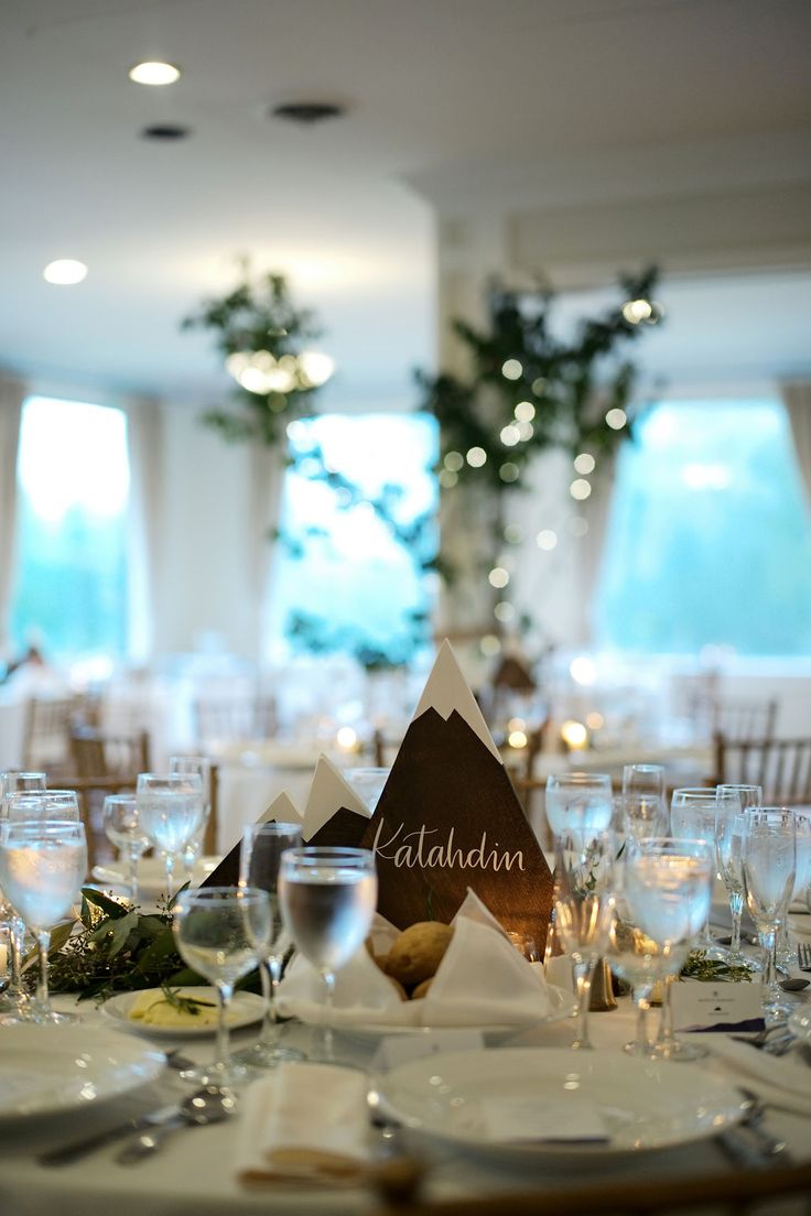 the table is set with wine glasses and place settings