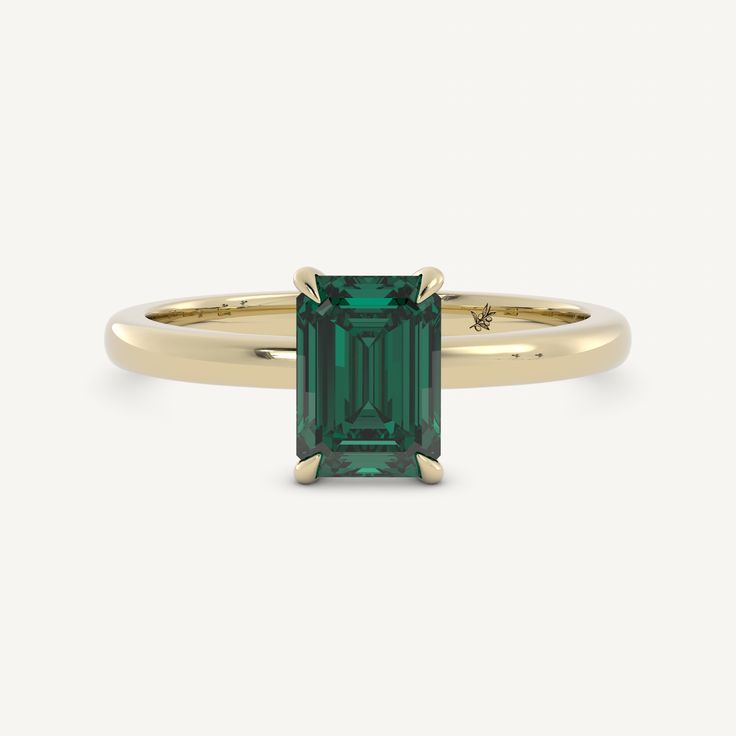 an emerald colored ring with gold band