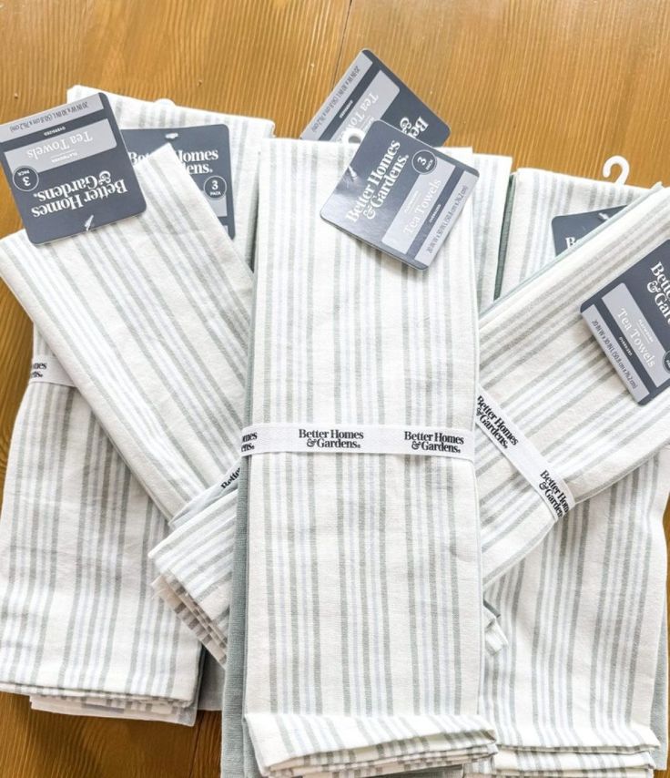 five folded towels sitting on top of a wooden table