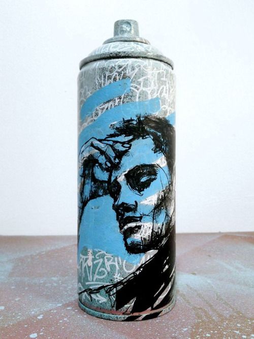 a can that has some writing on it with a man's face painted on it