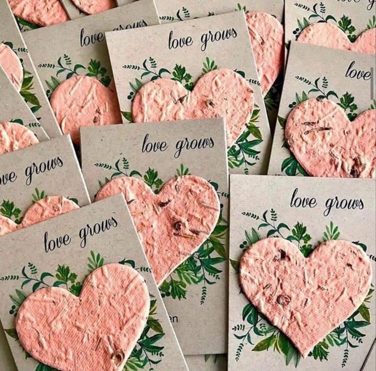 some pink heart shaped cookies with love grows written on the front and back of them