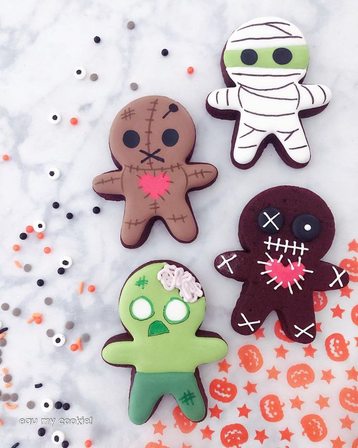 three decorated cookies sitting on top of a table