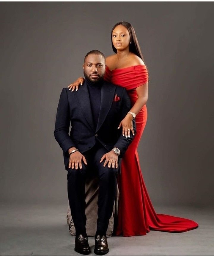 a man and woman posing for a photo in formal wear, one is wearing a red dress