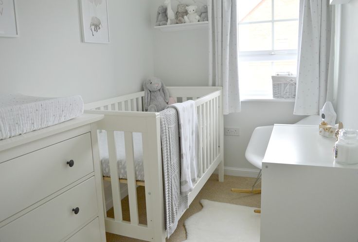 a baby's room with a crib, dresser and window