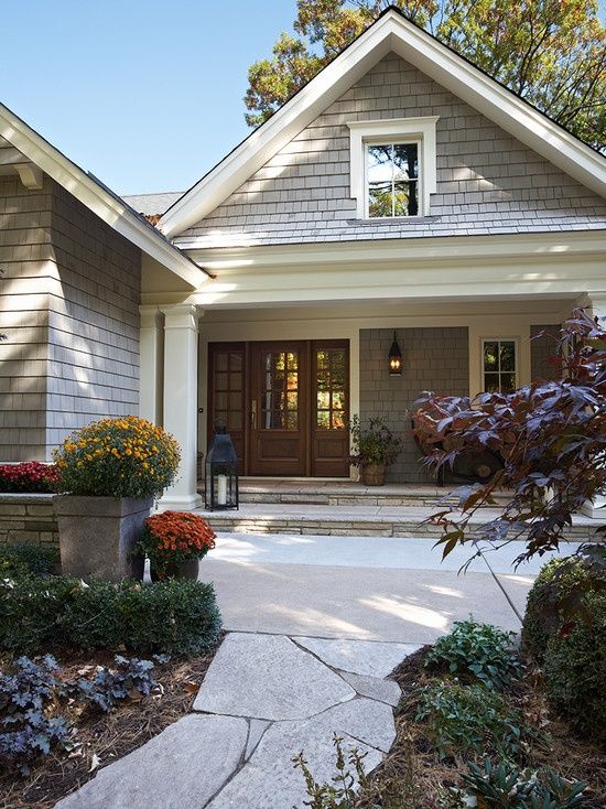 a house with two large planters in front of it and a walkway leading to the front door