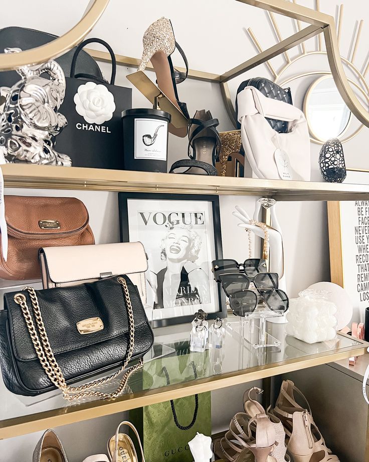 a shelf filled with purses and shoes on top of a glass topped table next to a mirror