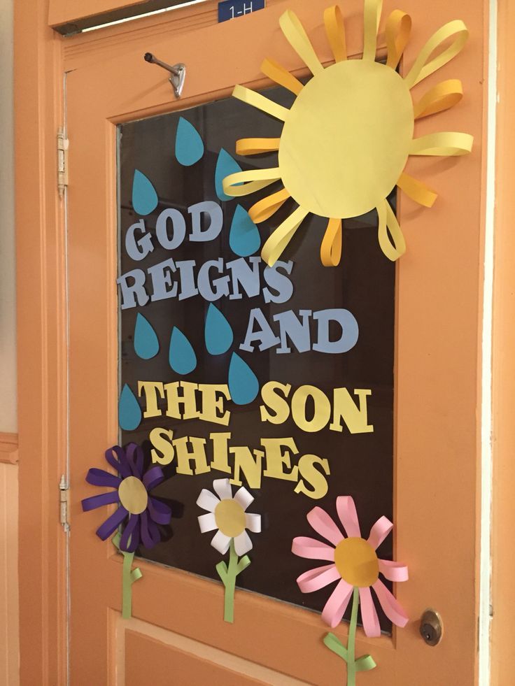 a door decorated with paper flowers and the words god reigns and the son shines