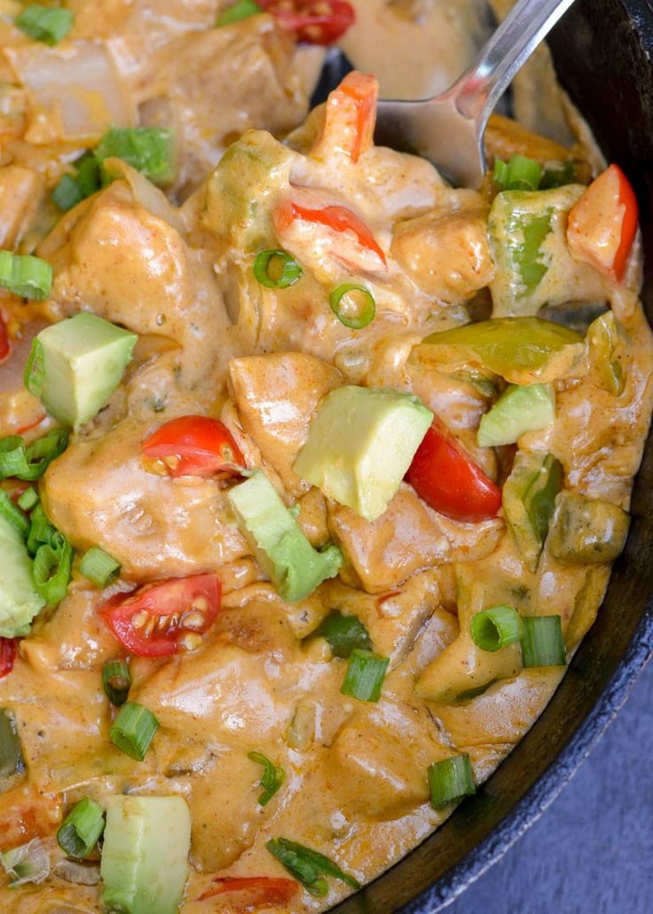 a skillet filled with chicken and veggies on top of a blue table