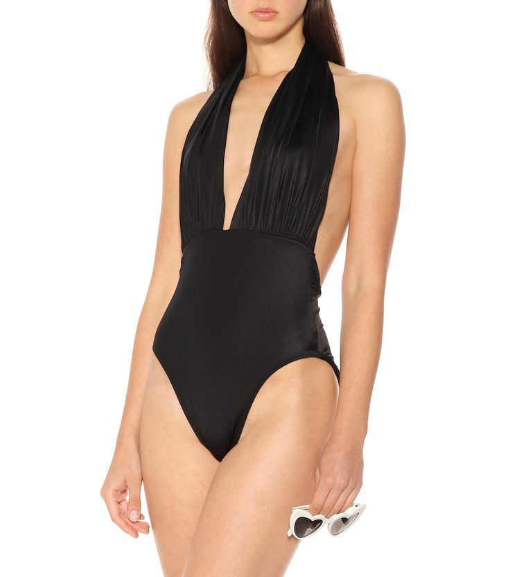 Mio Swimsuit in Black - Norma Kamali | Mytheresa Beachwear Bodysuit For Pool With T-back, Elegant Backless Halter Top For Beach Season, Backless Elastane Bodysuit For Summer, Summer Backless Elastane Bodysuit, Backless Summer Bodysuit In Elastane, Elegant Halter Neck Top For Poolside, Chic Low Back Swimwear For Beach Season, Chic Low-back Swimwear For Beach Season, Chic Halter Neck Elastane Bodysuit