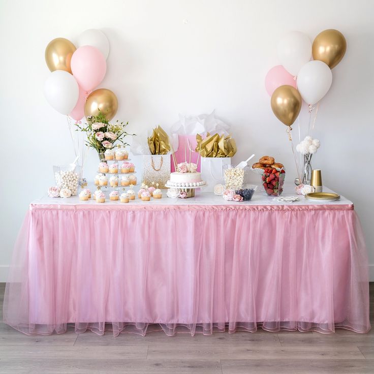 a table topped with lots of desserts and balloons