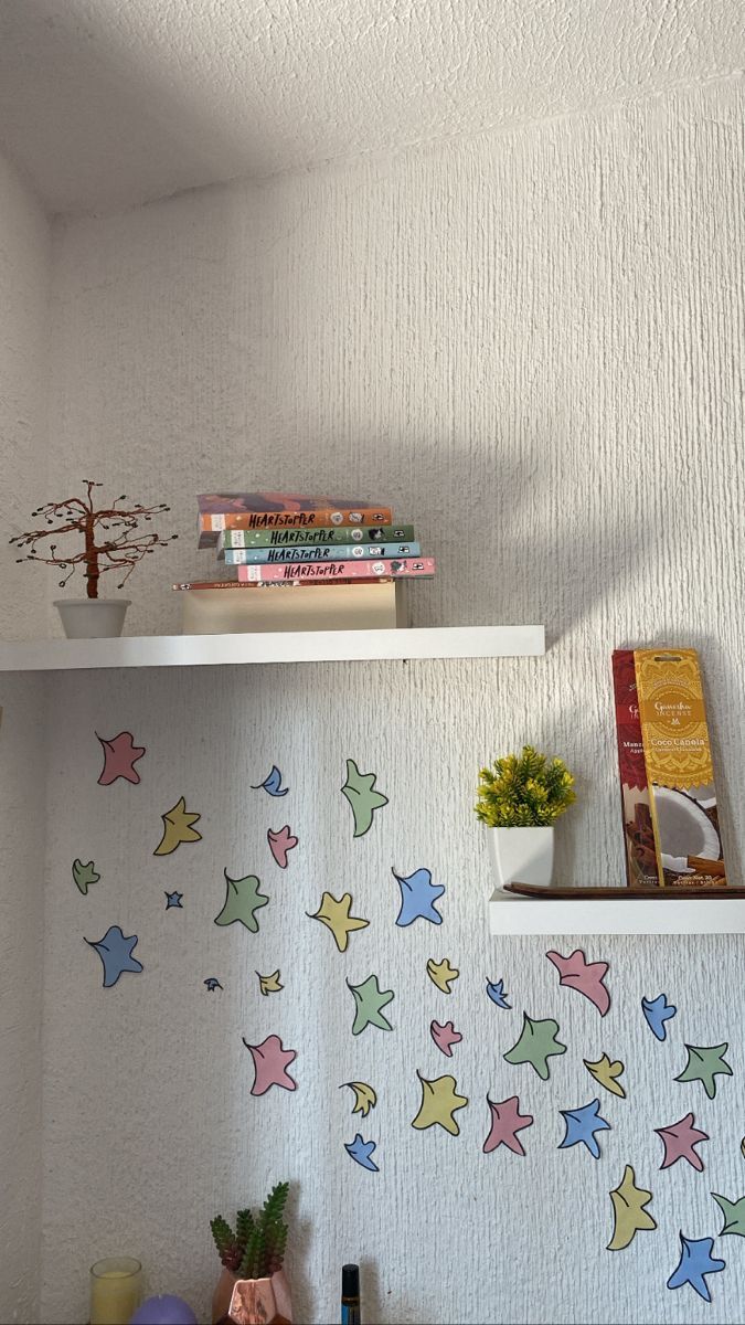 a shelf with books and other items on it in a room that has white walls