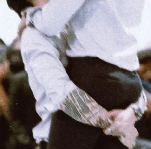 a man wearing a white shirt and tie standing in front of a group of people