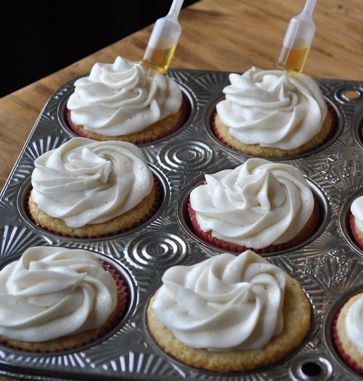 cupcakes with white frosting in a muffin tin