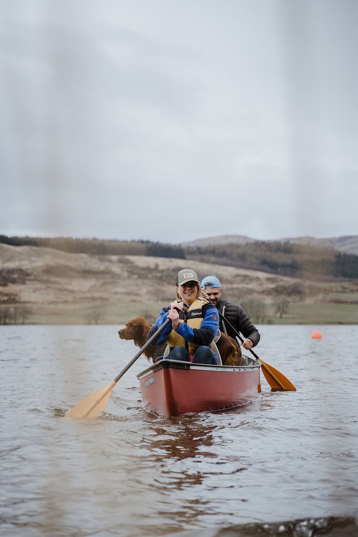 two people in a canoe with a dog