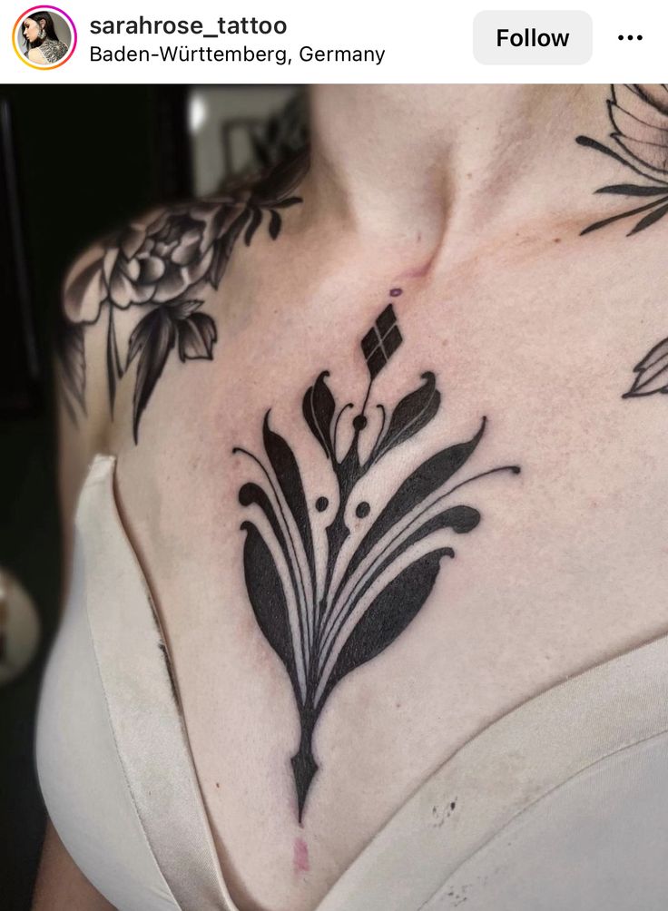 a woman's chest with flowers and leaves tattooed on the top part of her body